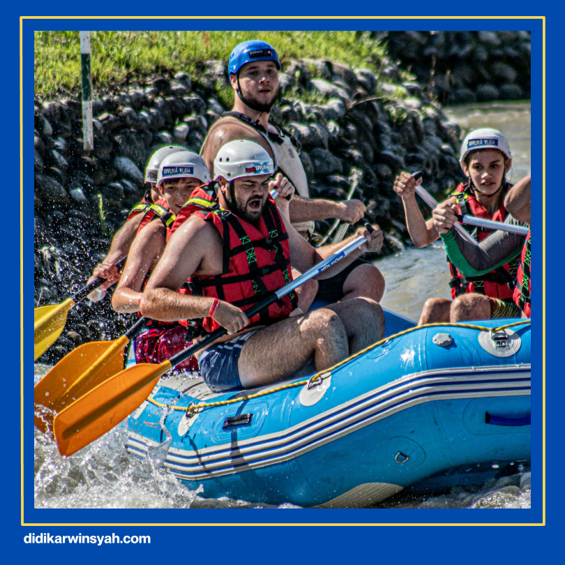 Pemandu rafting berpengalaman sedang memeriksa peralatan rafting berkualitas, termasuk perahu karet tangguh dan dayung, memastikan keamanan peserta